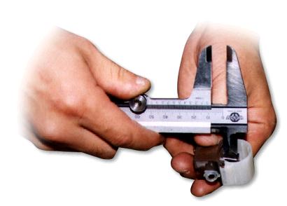 Close-up of a person measuring a metal device Description automatically generated